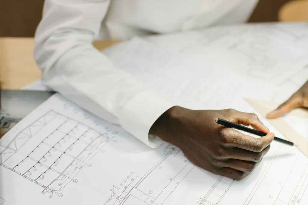 A hand drawing a plan with a pencil
