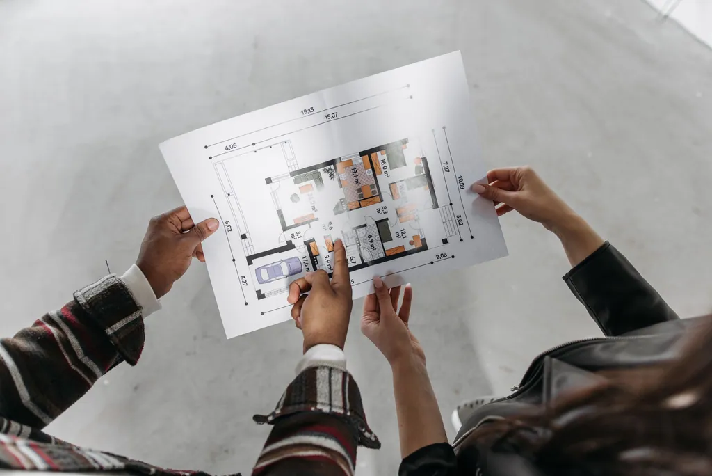 Two people reading a house plan together